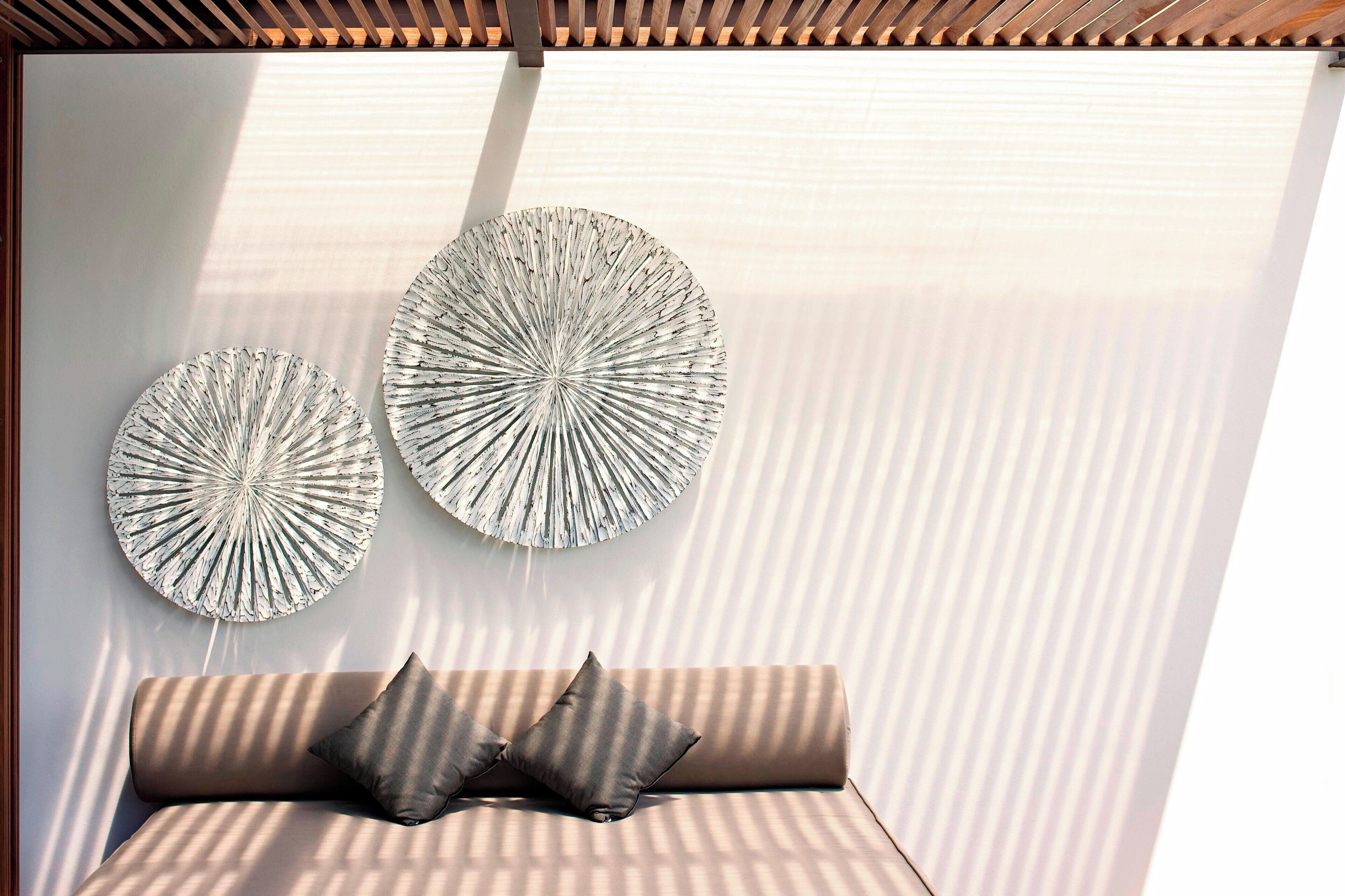 A modern room with a sofa and two wall-mounted circular decorative pieces.
