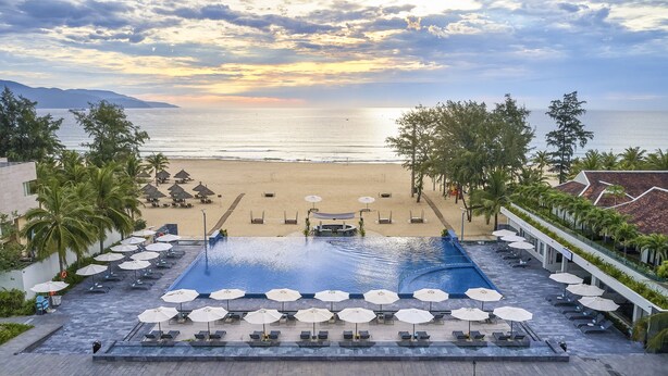 Un resort con piscina, playa y vista al océano.