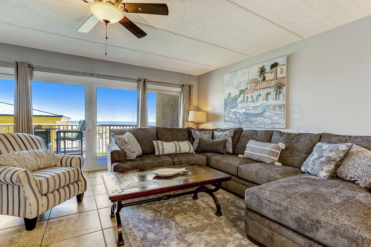 A living room with a sofa set, a coffee table, and a painting on the wall.