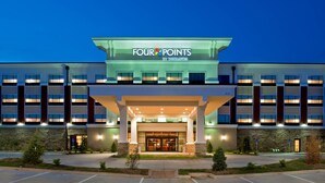 A Four Points by Sheraton hotel with a modern facade, large windows, and a well-lit entrance.