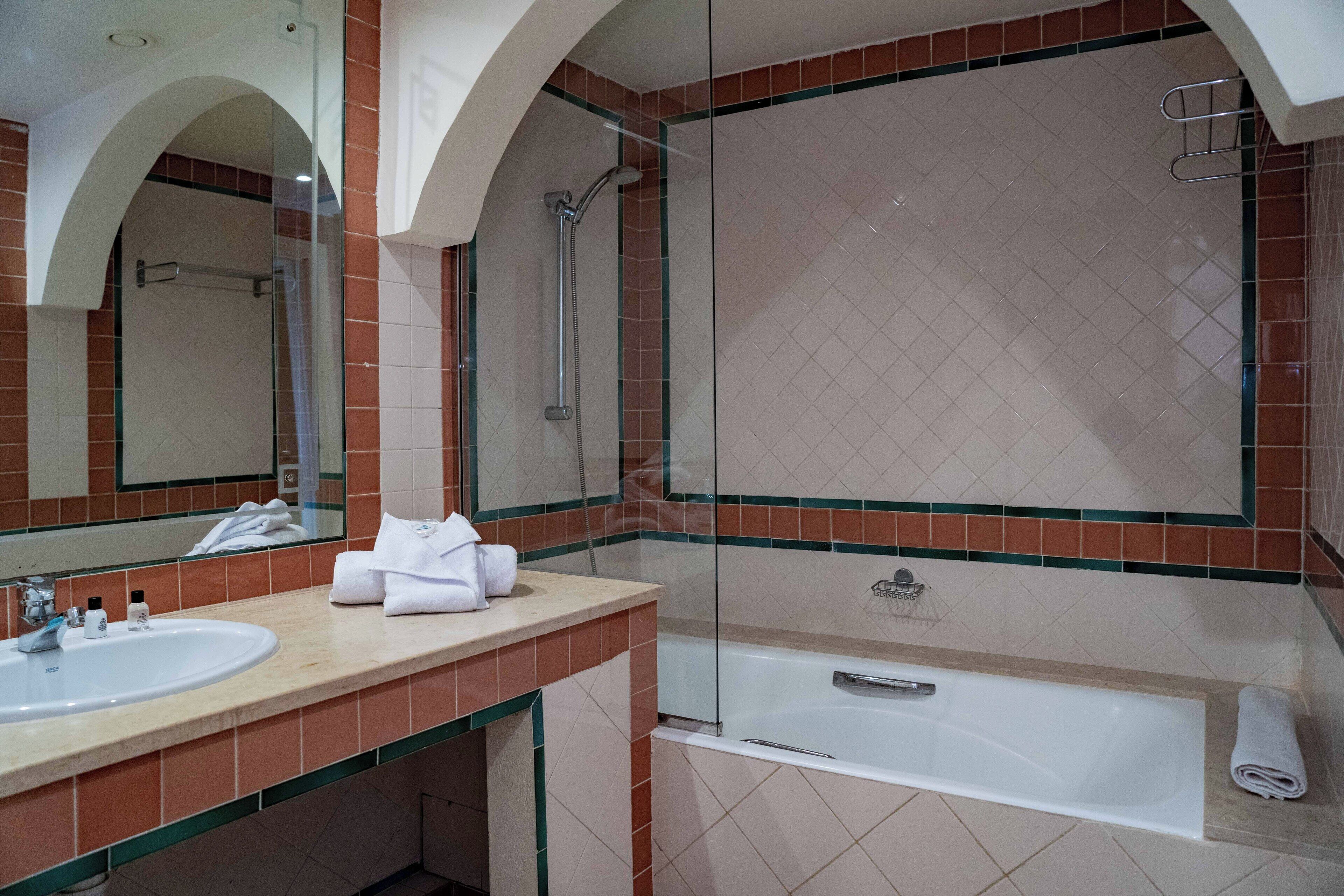 Une salle de bain avec un lavabo, un miroir et une baignoire.
