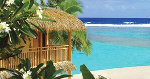 A beachside hut with a thatched roof, overlooking a clear blue ocean. - Sanctuary Rarotonga-On the beach - Adults Only (Rarotonga)