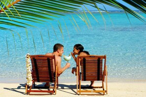 Privat strand, hvit sand, solsenger og strandhåndklær