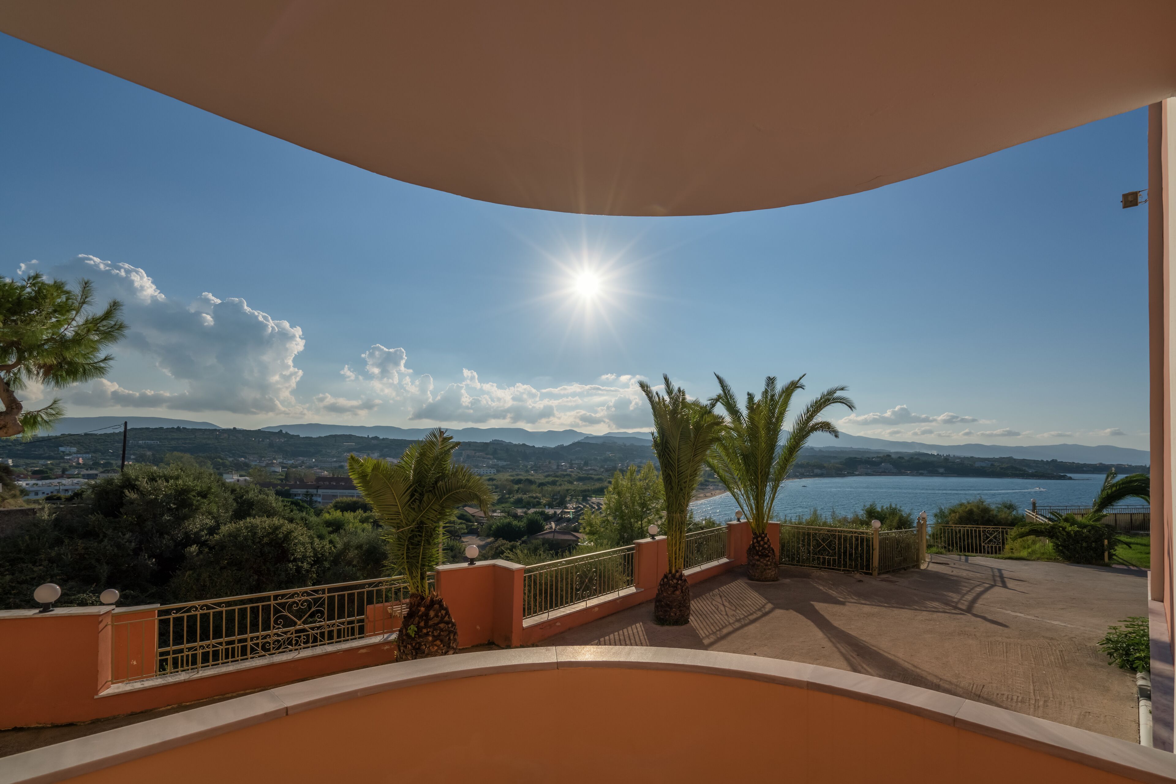 Un balcón con vista a un lago, montañas y un cielo despejado.