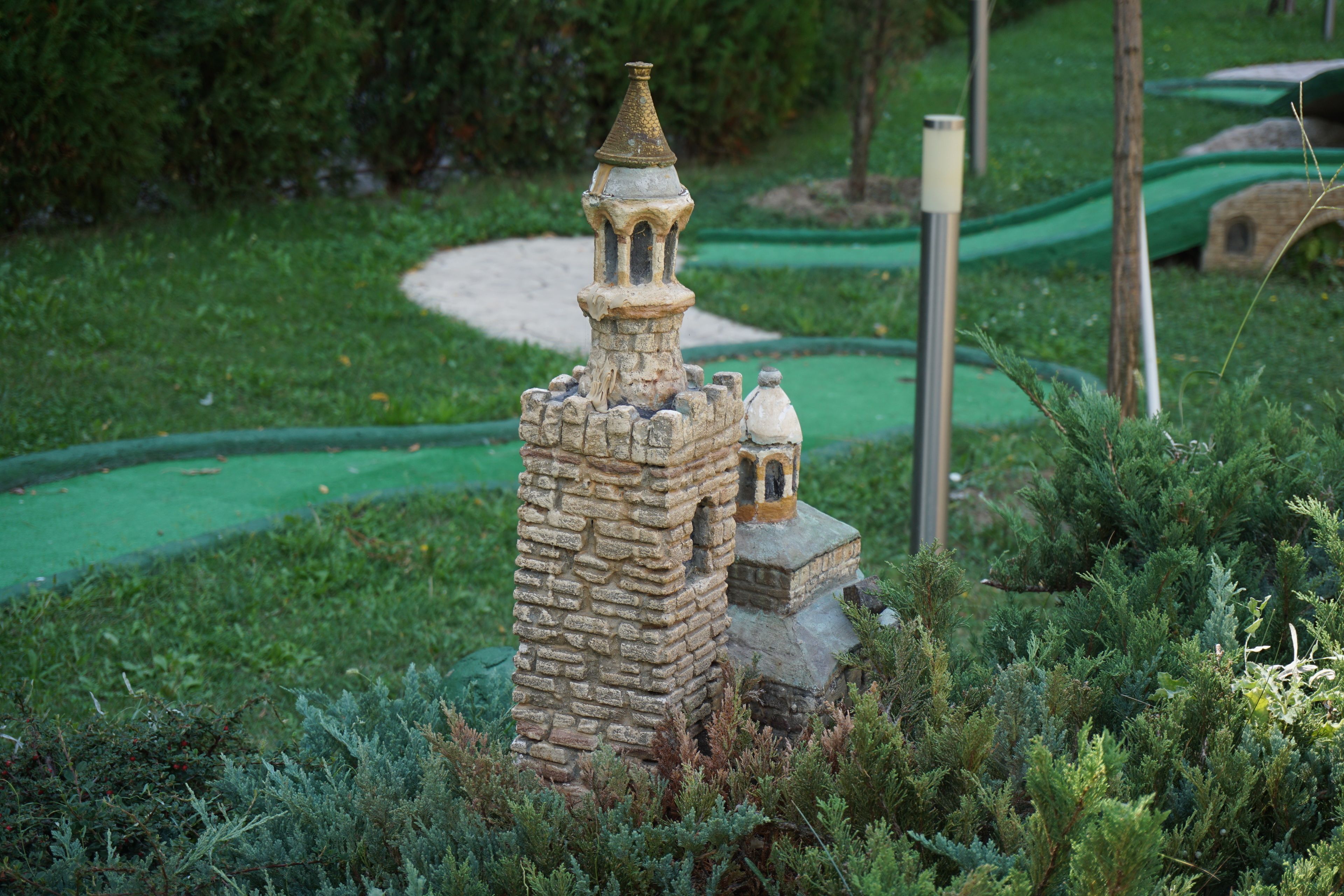 A miniature castle model surrounded by greenery.