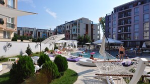 A pool area with lounge chairs, umbrellas, and a hammock. - Rainbow 3 Resort Club (Sunny Beach)