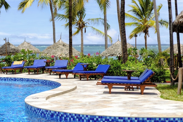 Una piscina al aire libre, sillones reclinables de piscina