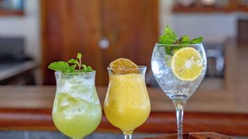 Three glasses of beverages on a wooden tray.