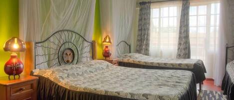Een hotelkamer met twee bedden, een nachtkastje en een lamp.