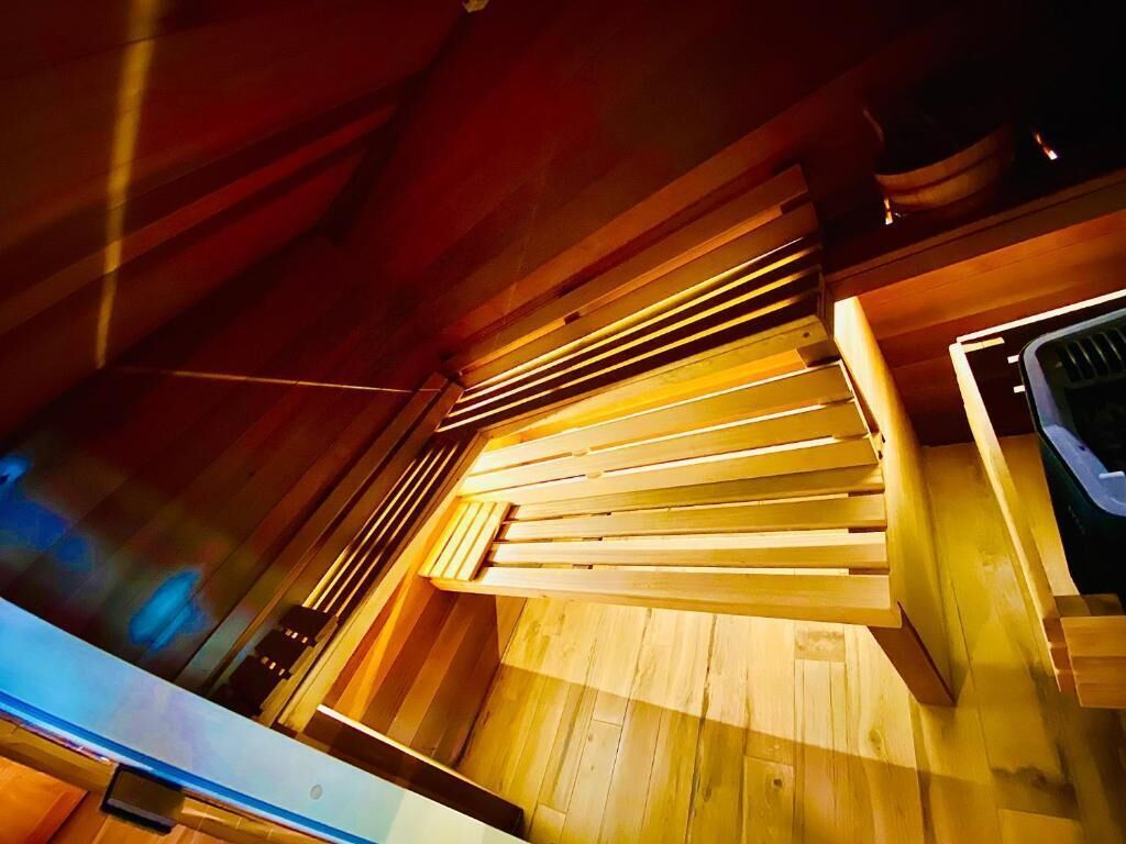 Een houten interieur met een plafond van latten, een zichtbaar raam en een deur.