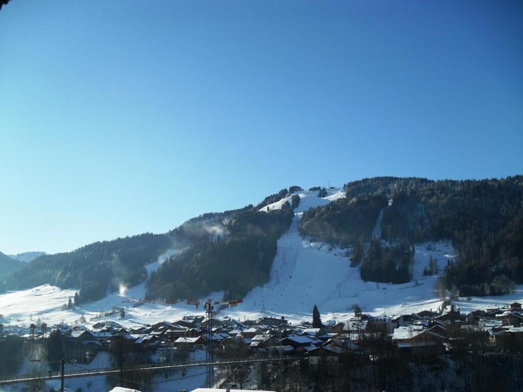 A snow-covered mountain with a ski resort in the foreground.