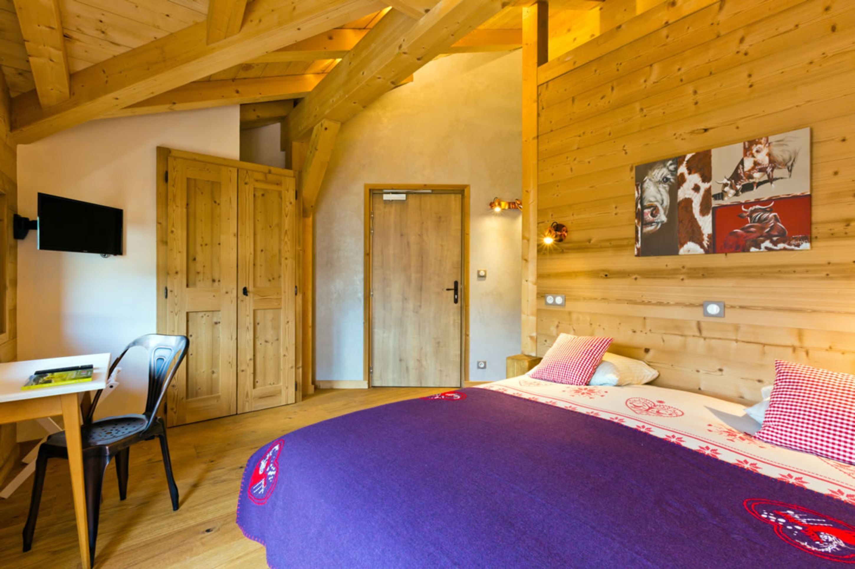 Une pièce en bois avec un lit, un bureau et une chaise.