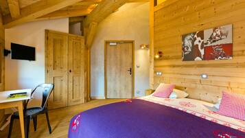 Une pièce en bois avec un lit, un bureau et une chaise.
