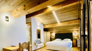 Un interior de madera con una cama, un escritorio y una silla.
