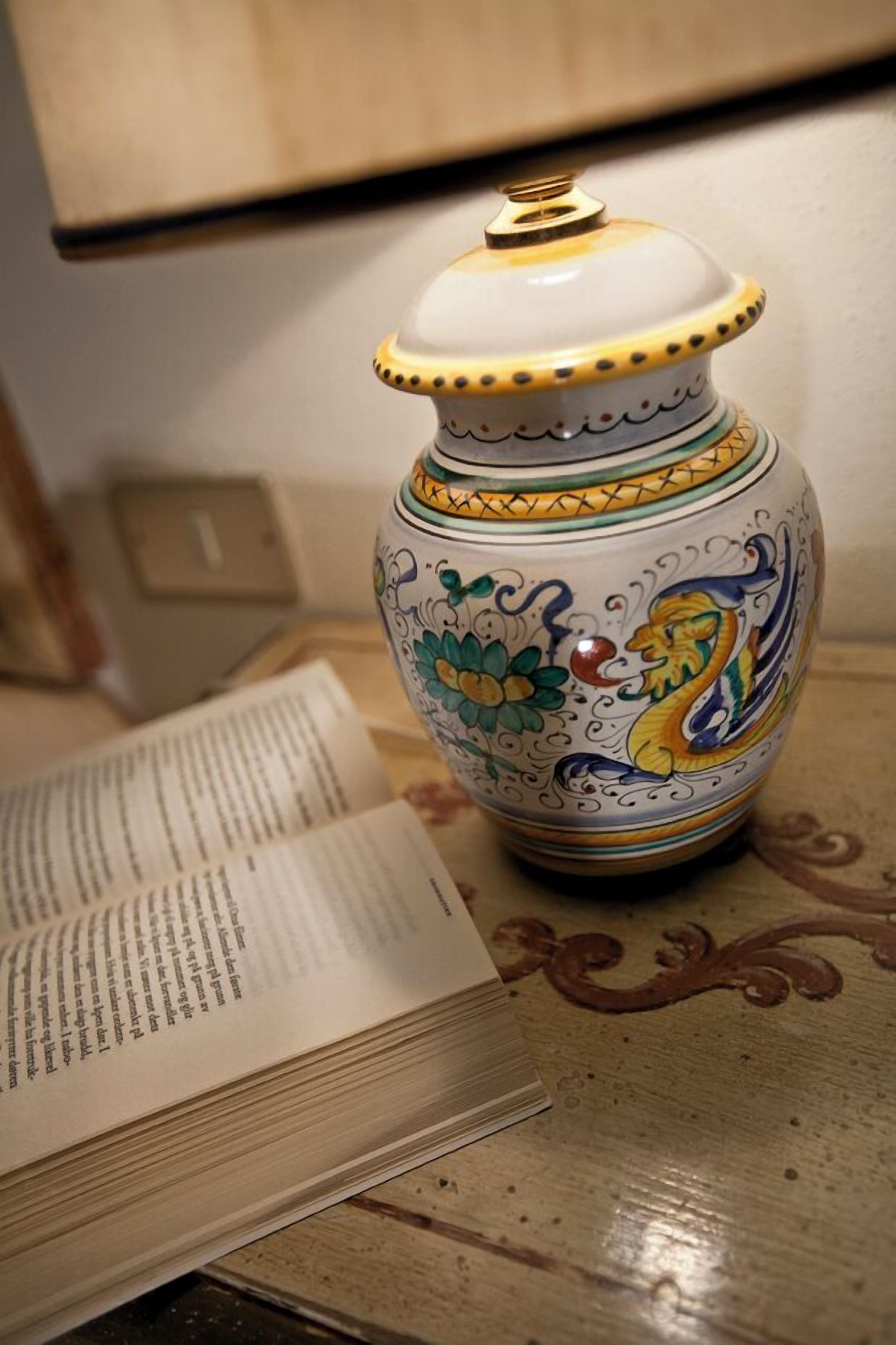 Eine dekorative Keramikvase mit aufwendigen Verzierungen und Deckel auf einer Holzoberfläche.