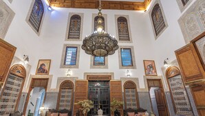 Un intérieur somptueux, agrémenté d’un grand lustre, de motifs complexes sur les murs et de meubles de style traditionnel.