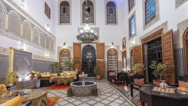 Un intérieur spacieux agrémenté de carreaux de céramique décoratifs, d’une fontaine centrale et de meubles de style traditionnel.