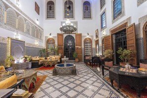 A spacious interior with ornate tile flooring, a central fountain, and traditional furnishings. - Riad Ghita (Fes)
