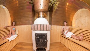 A sauna with wooden benches and a central heating unit. - Hotel Pedranzini (Valfurva)