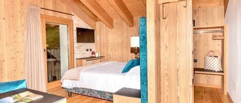 Una habitación de cabaña de madera con una cama, una mesita y un banco.