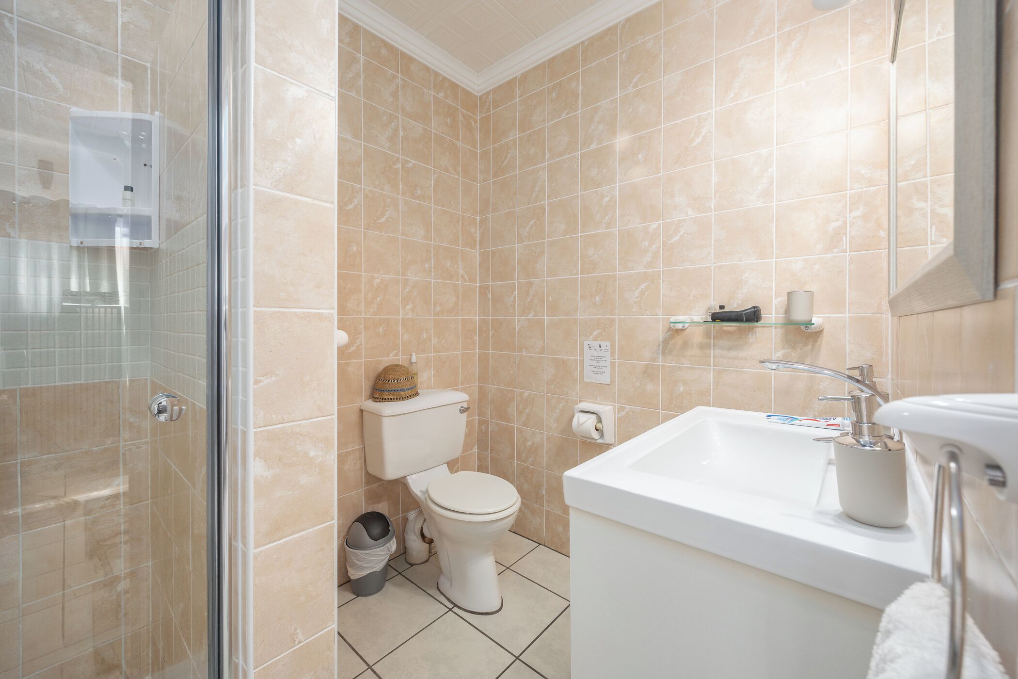 A bathroom with a toilet, sink, and shower area.