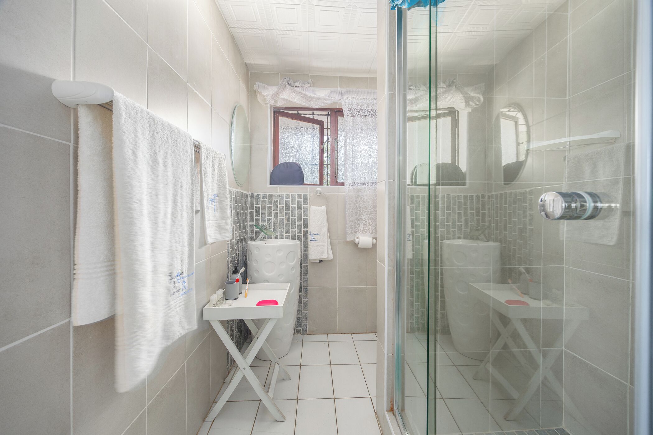 A compact bathroom with a shower, a toilet, and a sink.