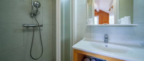 A bathroom with a shower, sink, and mirror.