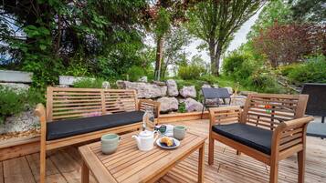 Un espace extérieur aménagé avec du mobilier en bois et une table dressée pour deux personnes.