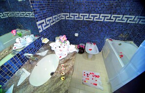 A bathroom with a blue mosaic wall, a bathtub, a sink, and a toilet. - Hôtel Nouzha La perle du tourisme (Fes)