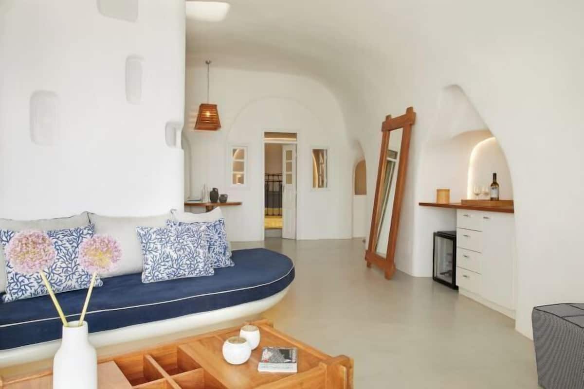 Een modern interieur met een gebogen bank, een houten salontafel en een spiegel.