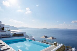 A clear blue sky, a swimming pool, and a view of the sea.
