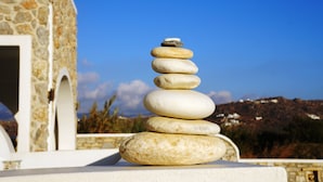 A stone building with a white door and a stone wall. - Blue Harmony Apartments (Naxos)