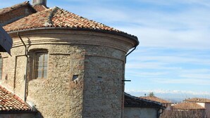 A stone building with a tiled roof and a small tower. - L'Angolo di Rosina (Novello)
