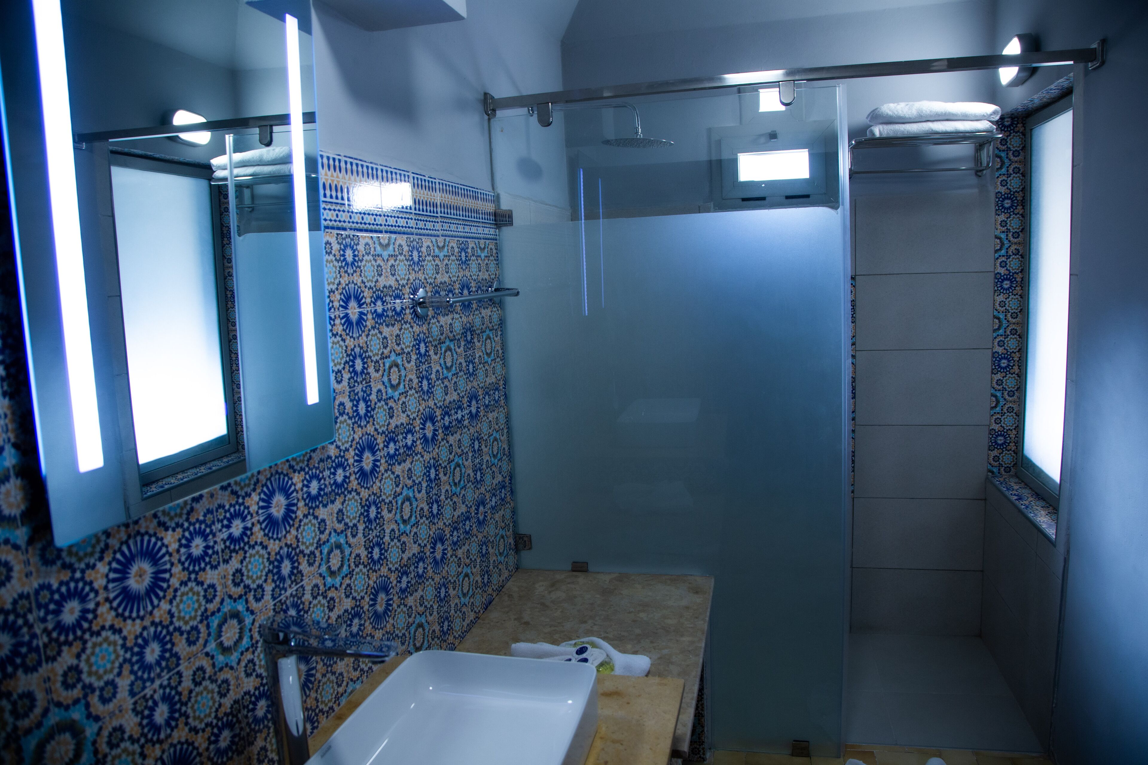 A bathroom with a shower, a sink, and a mirror.