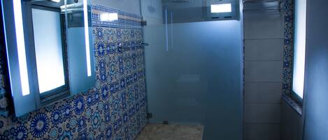 A bathroom with a shower, a sink, and a mirror.
