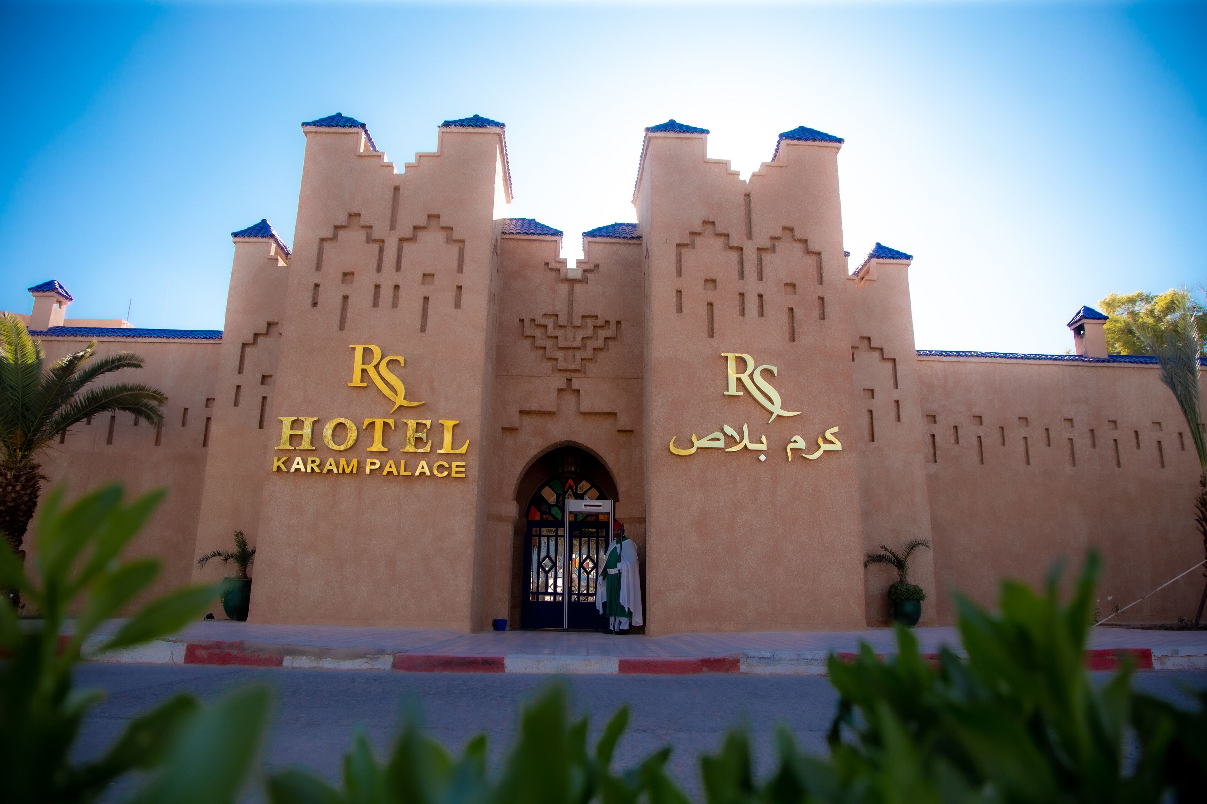 A hotel facade with a castle-like design, featuring two prominent towers and a central entrance.