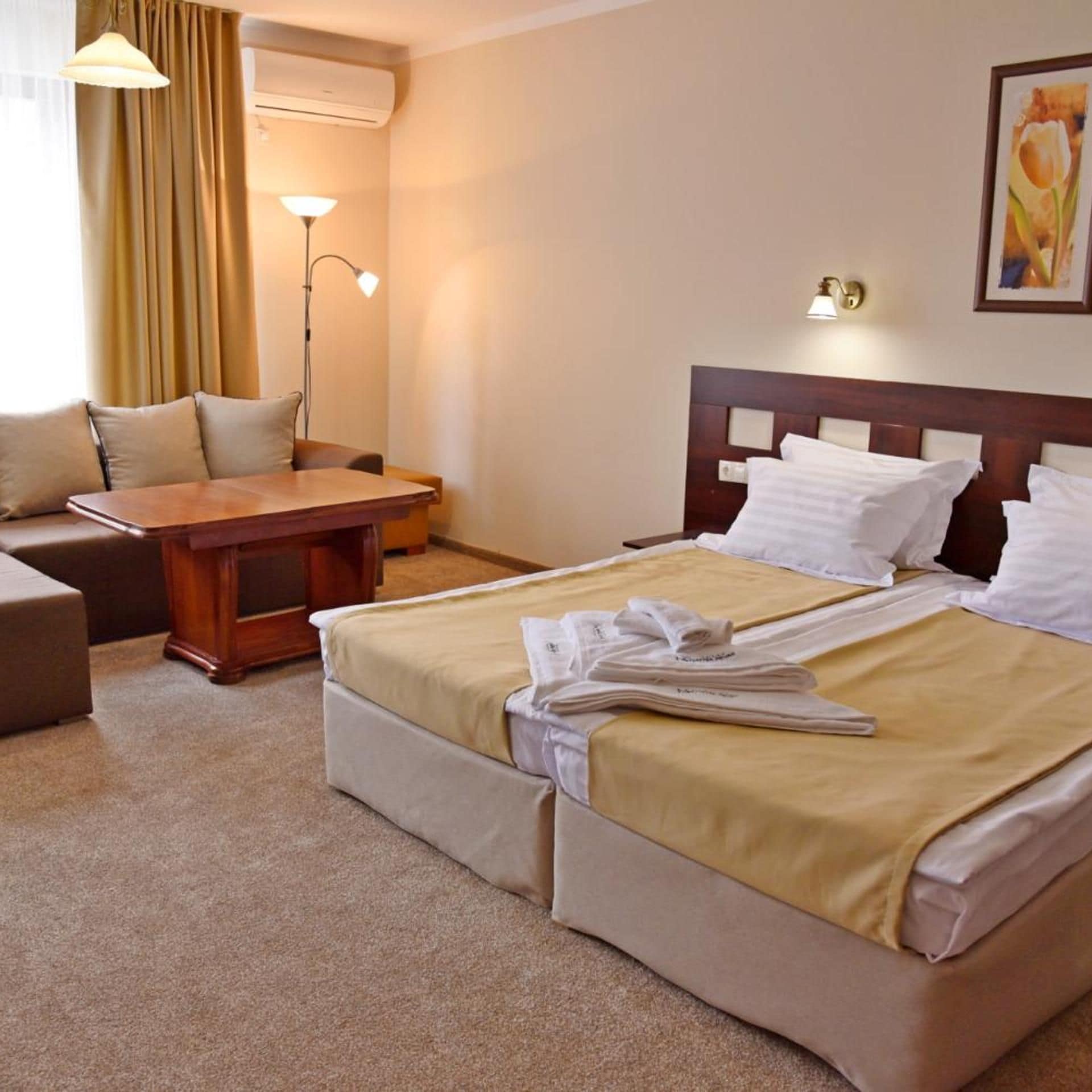 Een hotelkamer met een bed, een bureau, een stoel en een lamp.