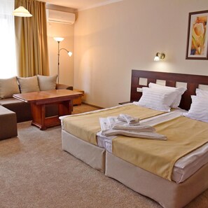 Una habitación de hotel con una cama, un escritorio, una silla y una lámpara.
