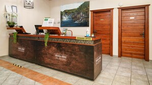 Una mesa de recepción con un cartel que dice 'EXCHANGE OFFICE' y 'VRATA KRKE Hotel'.