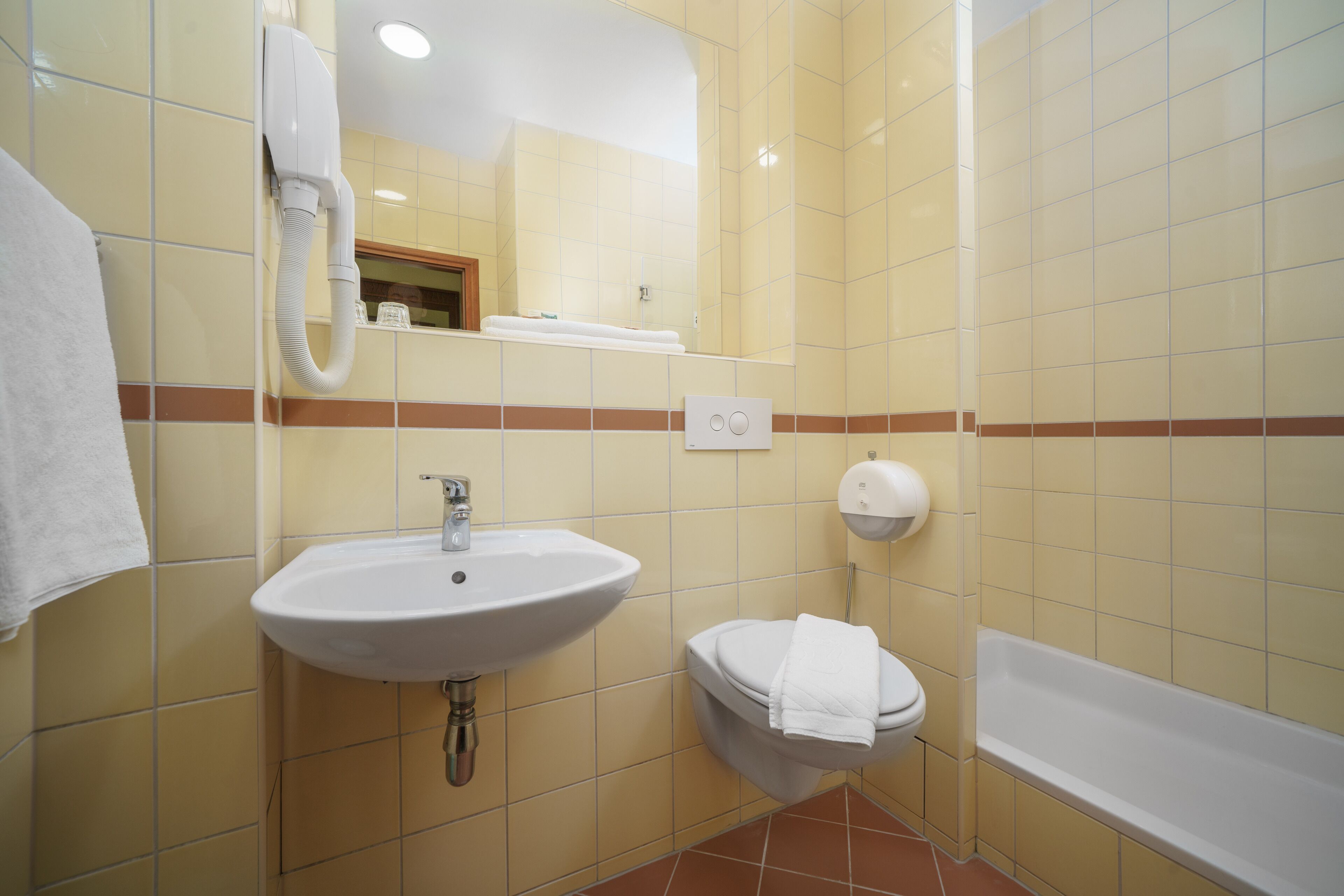A bathroom with a sink, toilet, and bathtub.