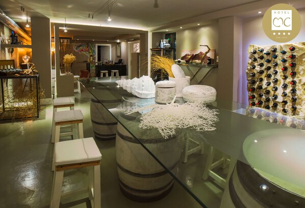 A modern bar area with a glass countertop, stools, and a wine rack.