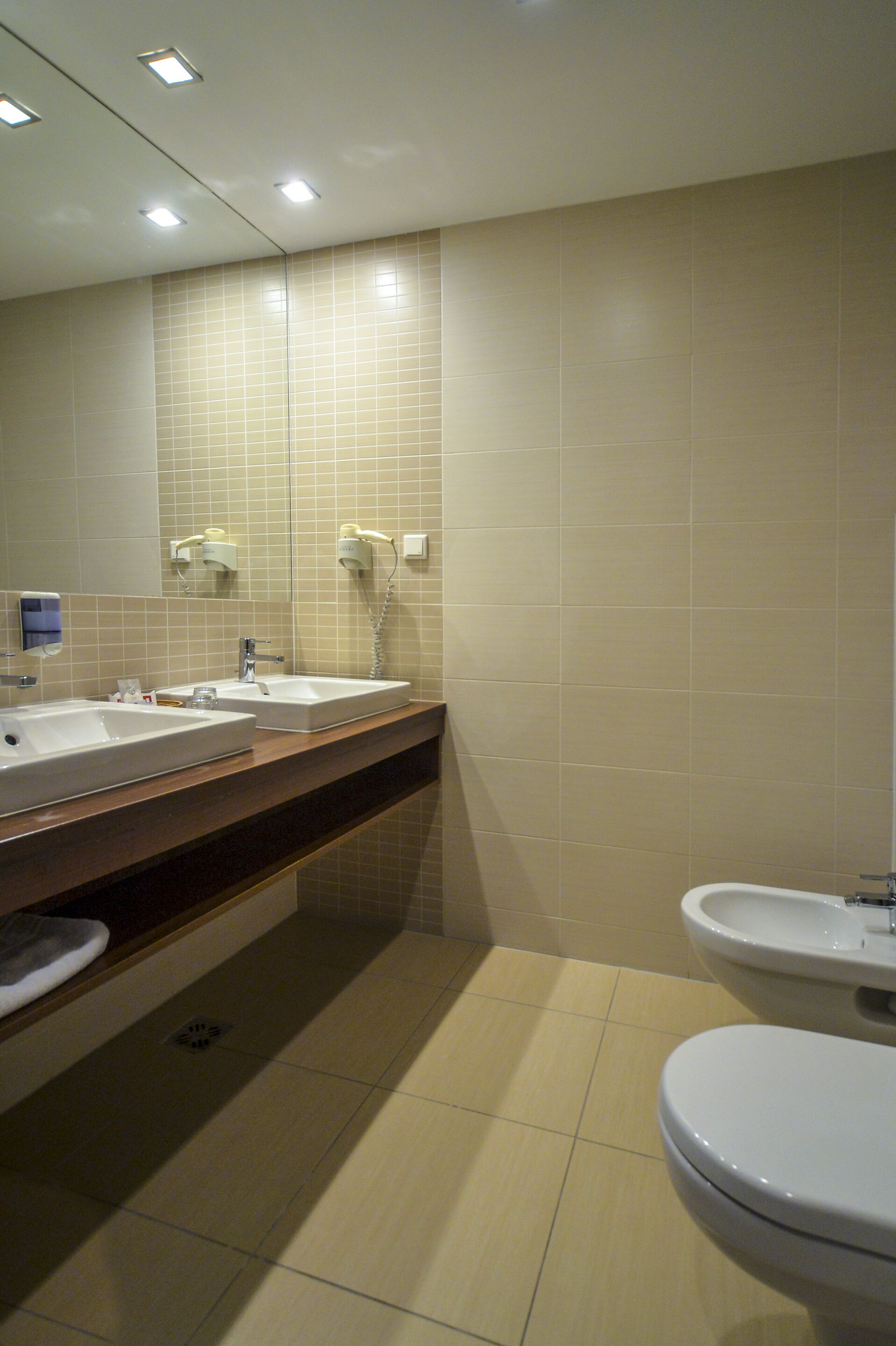 Une salle de bain avec deux lavabos, un miroir et des toilettes.