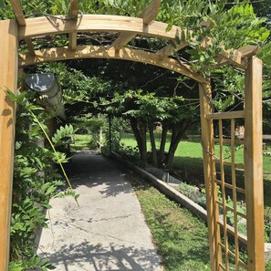 A wooden pergola structure with a pathway underneath. - Hôtel De France Restaurant Grill - Domfront (Domfront en Poiraie)