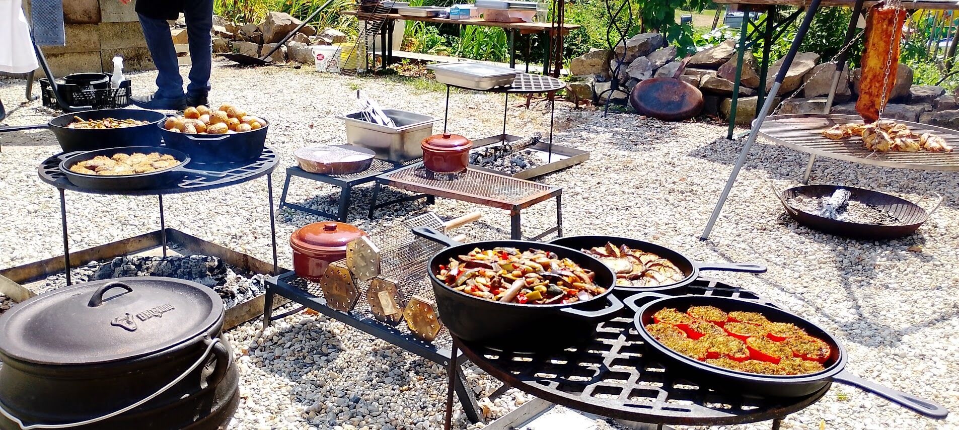An outdoor cooking setup with multiple grills and pots.
