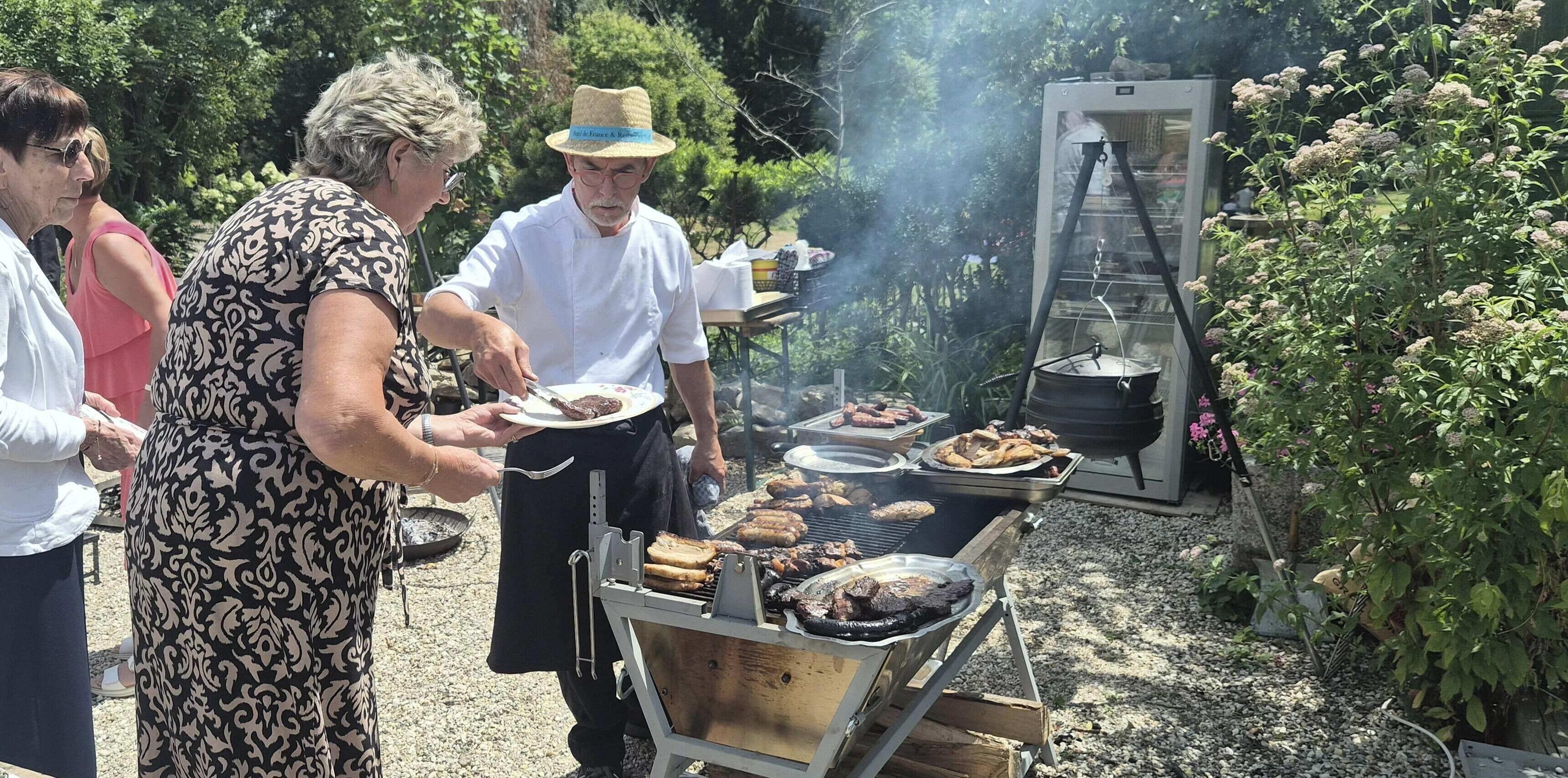 An outdoor barbecue with a grill and a portable stove, surrounded by greenery.