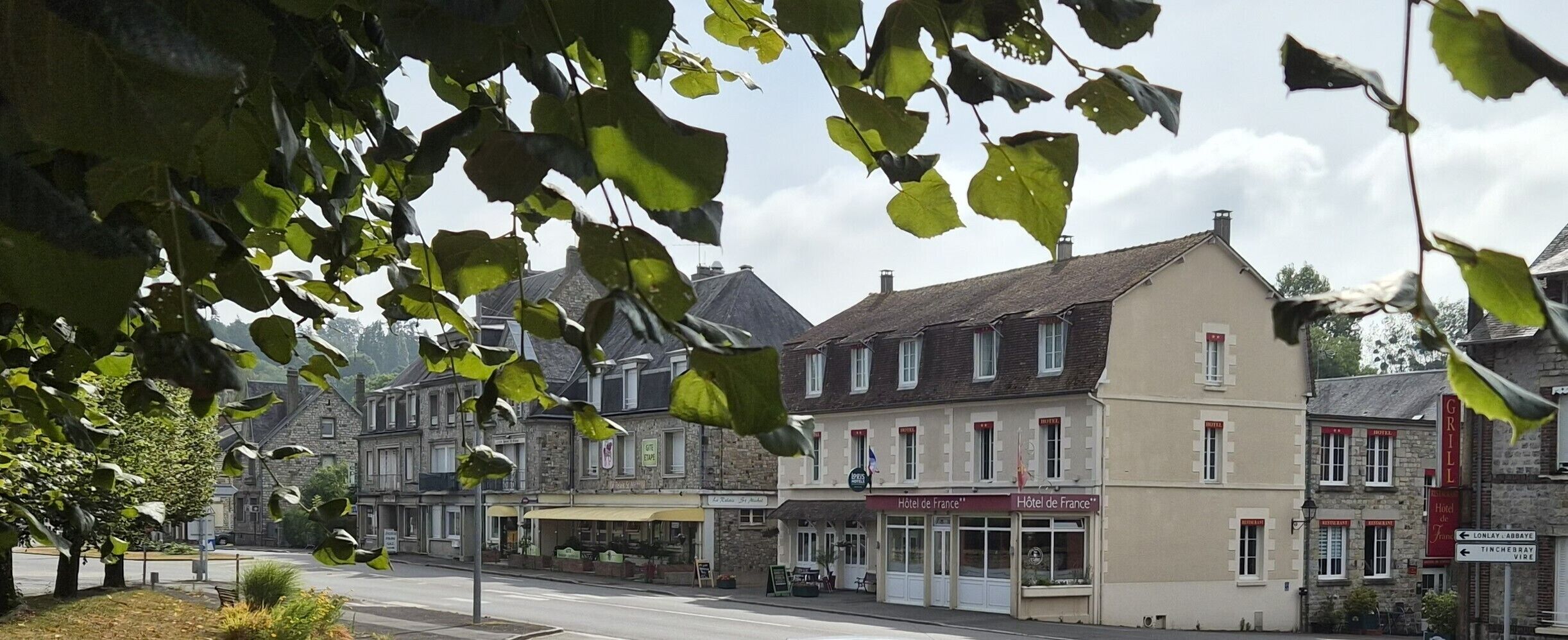 Una hilera de edificios con varios letreros de hotel, incluyendo 'Hôtel de France'.
