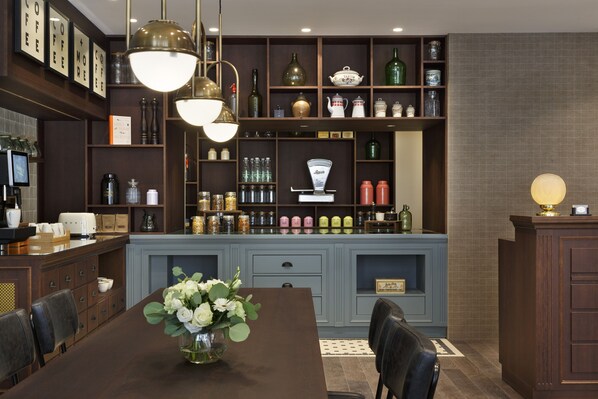 Una cocina moderna con armarios de madera oscura, una isla central y una variedad de utensilios de cocina y objetos decorativos en estantes.