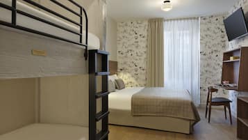 Une chambre avec des lits superposés, un bureau, une chaise et un téléviseur fixé au mur.