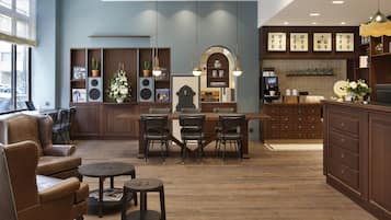 A modern kitchen with a central island, wooden cabinets, and a seating area with a sofa and chairs.