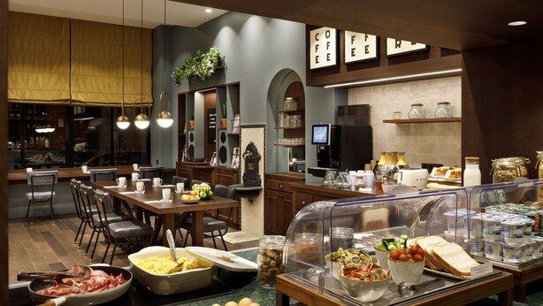 En buffet med forskellige retter, kaffestation og siddepladser.